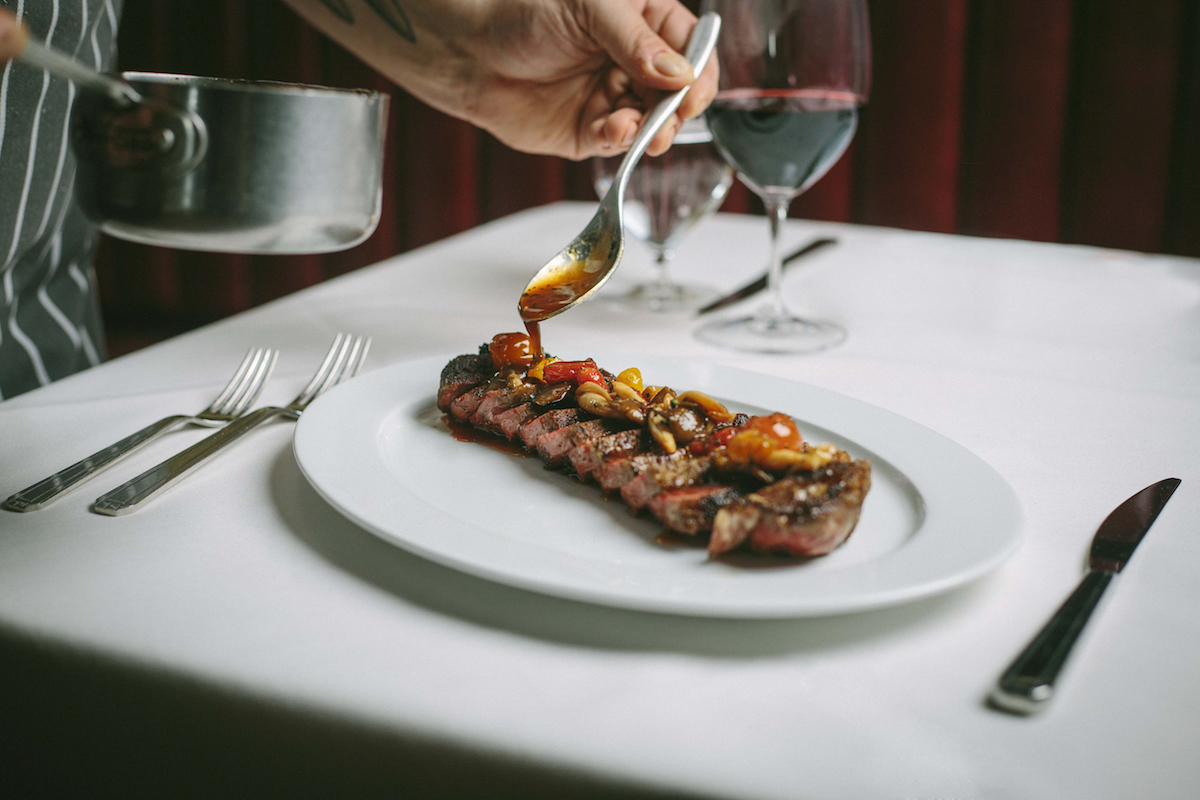 Steak gets finishing touches at the table at Tango Room. | Photo by Doug Friedman