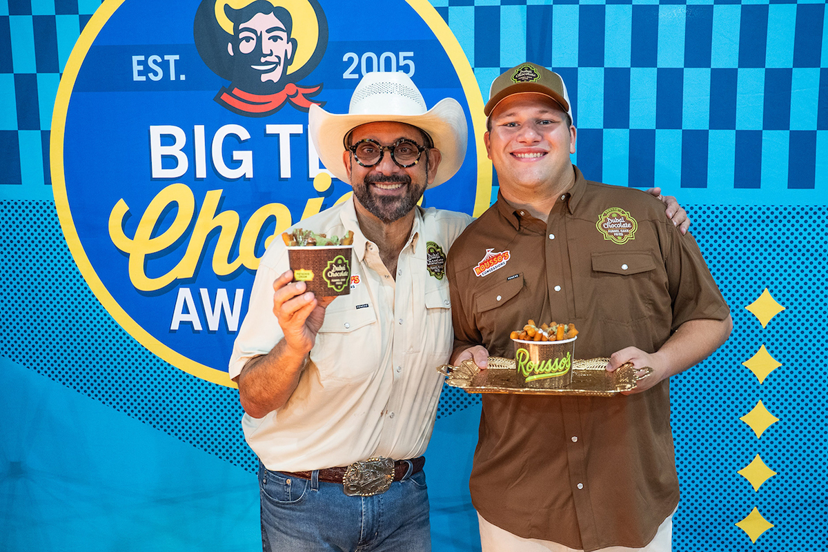 A pair of fair attendees pose with Dubai chocolate funnel cake fries at the State Fair of Texas. | Photo by the State Fair of Texas